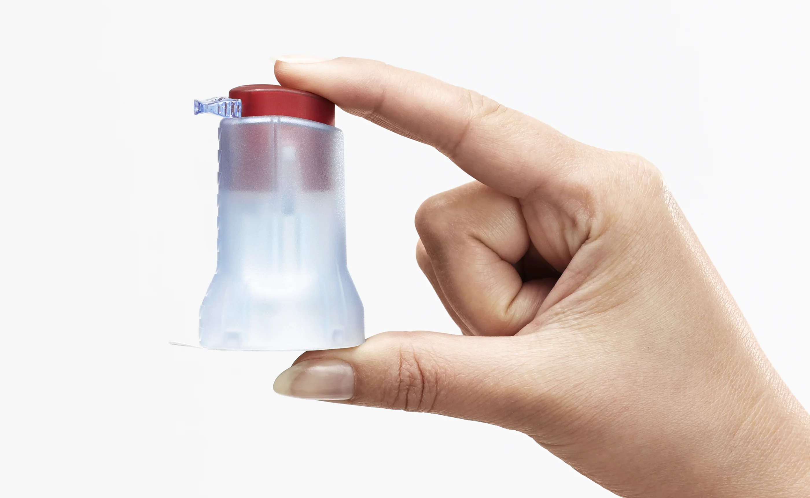 a hand holding a plastic bottle