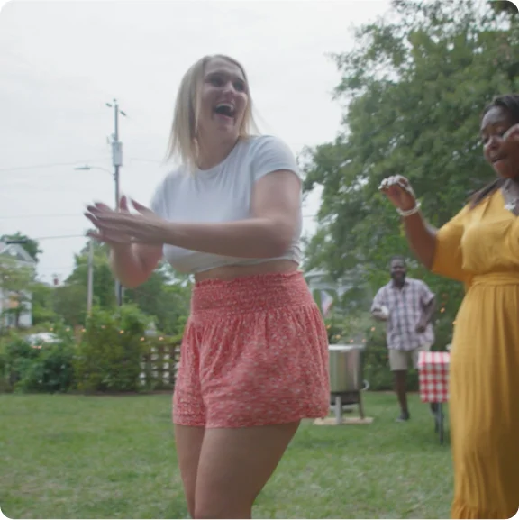 Grupa ludzi śmiejących się i tańczących.