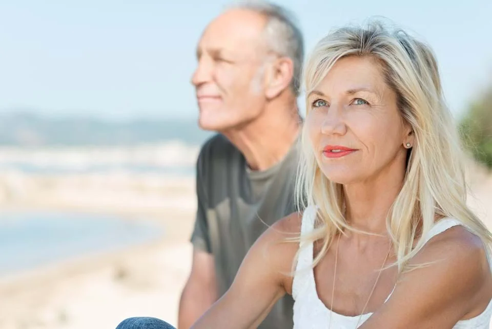 a man and woman standing on a beach