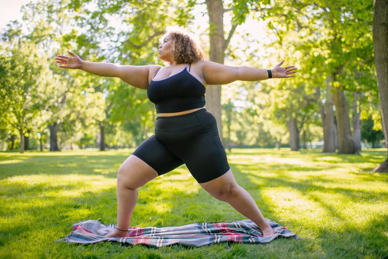 Frau, die Yoga-Pose im Park ausführt